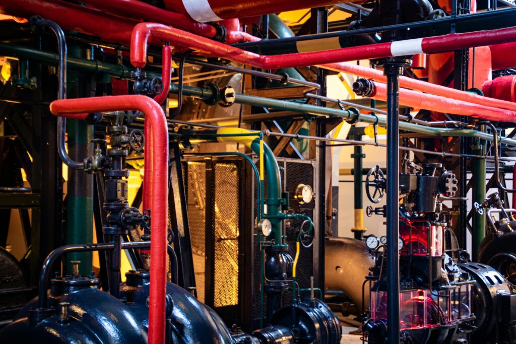 Complex network of industrial pipes and machinery inside a Lisbon plant.